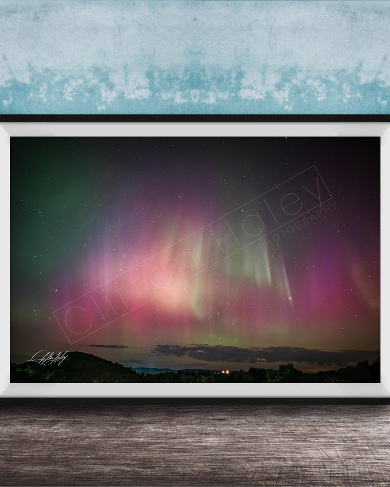 The image is a framed photograph of a night sky with the aurora borealis, or northern lights, visible.