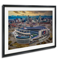 An aerial view of a large sports stadium, likely a football stadium, with the city skyline in the background.