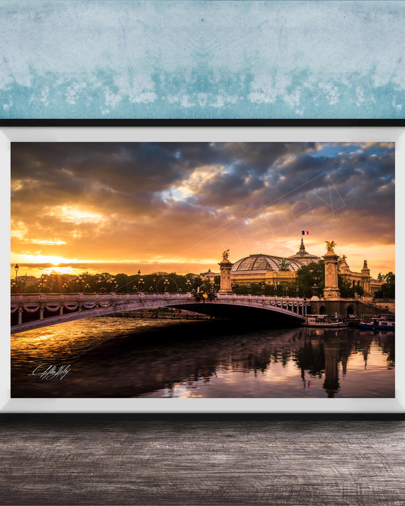 a picturesque scene of a bridge spanning a river, with a large domed building on the other side. The sky is filled with vibrant colors, suggesting either sunrise or sunset, and the water below reflects the stunning hues. The overall composition and the presence of the domed building create a sense of grandeur and beauty in the scene.