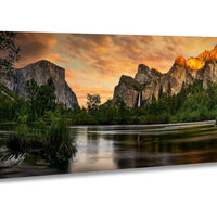a serene landscape with a calm river reflecting the vibrant colors of the sky, surrounded by towering mountains and lush greenery.