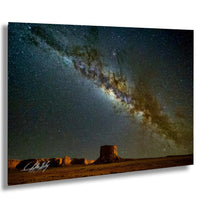 a stunning night sky with a large, bright star in the center, surrounded by a vast expanse of stars and a distant galaxy. The scene is set against a desert landscape with sand dunes and rock formations, creating a serene and awe-inspiring atmosphere.