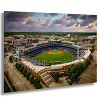 An aerial view of a baseball stadium with a well-maintained green field and surrounding buildings.