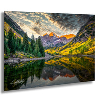 a serene mountain landscape with a calm lake reflecting the vibrant colors of the surrounding trees and mountains.