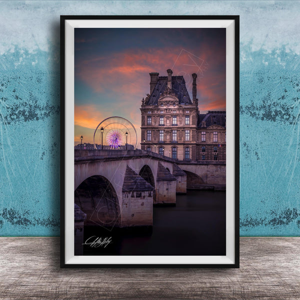 a large, ornate building with a ferris wheel in the background, set against a colorful sunset sky.