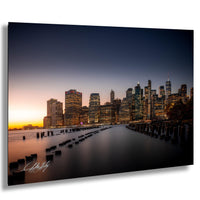 a city skyline at sunset, with tall buildings illuminated against a dark sky.