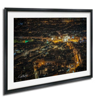 The image is a night view of a city, with numerous illuminated buildings and streets visible.
