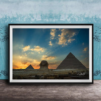 the Great Pyramids of Giza against a stunning sunset sky, with the Sphinx in the foreground.