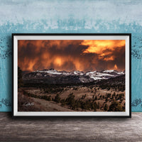 a breathtaking mountain landscape with a dramatic sky filled with clouds and fiery orange hues, creating a stunning and awe-inspiring scene.