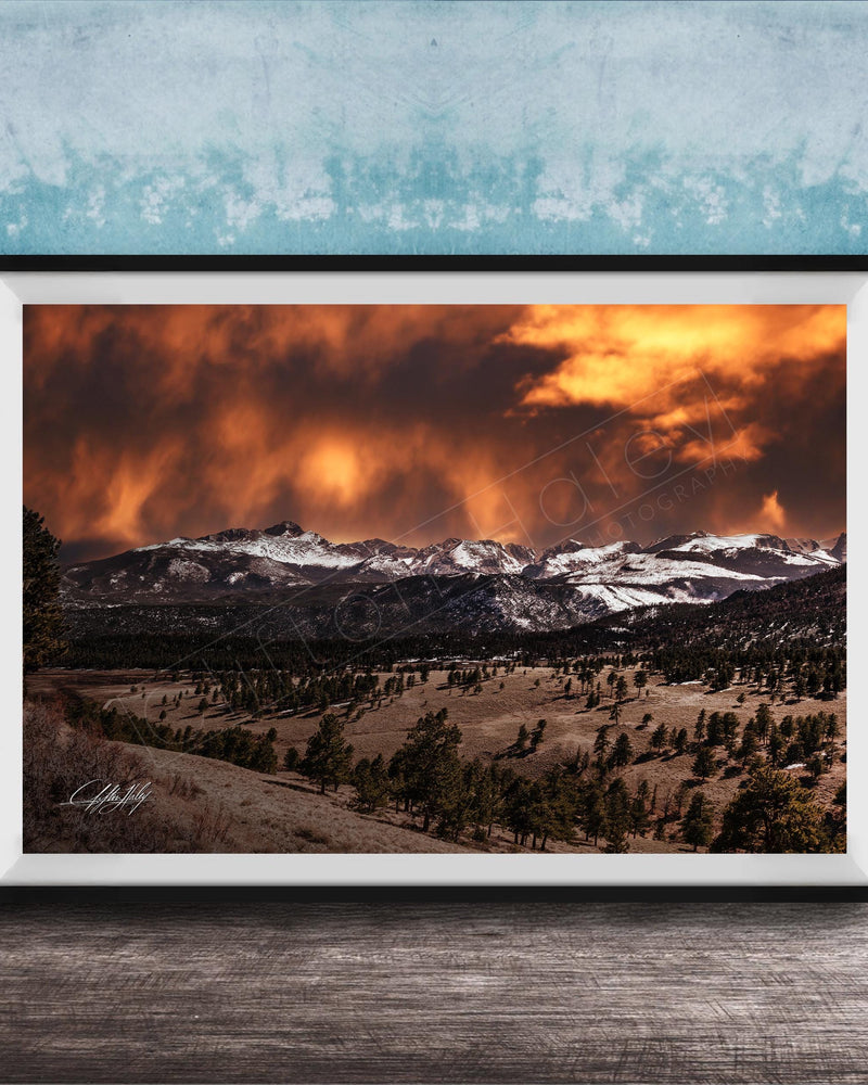 a breathtaking mountain landscape with a dramatic sky filled with clouds and fiery orange hues, creating a stunning and awe-inspiring scene.