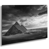 the iconic pyramids of Giza, Egypt, standing majestically against a dramatic cloudy sky.