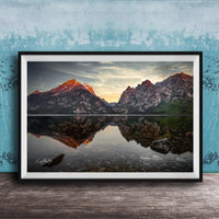 a serene mountain landscape with a calm lake reflecting the mountains and sky.