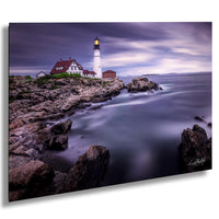 A picturesque lighthouse stands on a rocky shore, overlooking the calm, misty ocean under a dramatic sky.