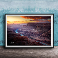 A framed photograph of a breathtaking view of the Grand Canyon, with a stunning sunset over the rugged, layered rock formations.