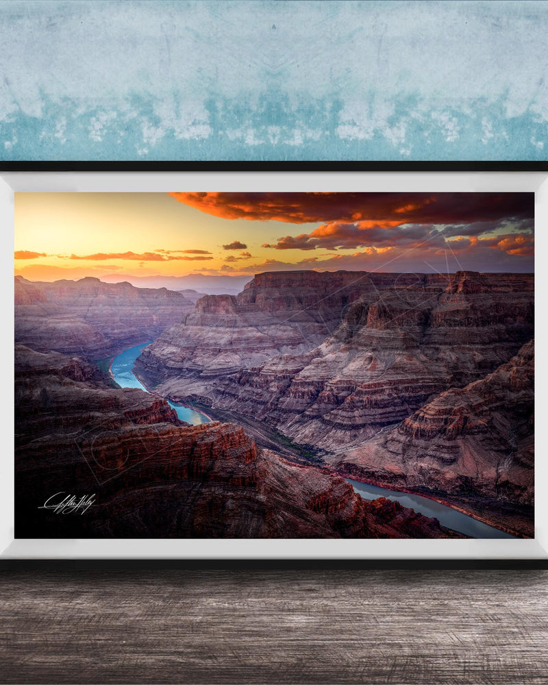 A framed photograph of a breathtaking view of the Grand Canyon, with a stunning sunset over the rugged, layered rock formations.