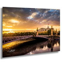 a picturesque scene of a bridge spanning a river, with a large domed building in the background and a stunning sunset casting a warm glow over the entire landscape.