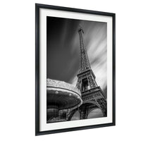 A black and white photograph of the Eiffel Tower in Paris, France, with a blurred background.