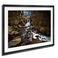 a serene waterfall cascading down a rocky cliff face, surrounded by a lush green forest.