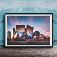 A framed photograph of the Guggenheim Museum in Bilbao, Spain, with its distinctive curved and metallic architecture against a colorful sunset sky.