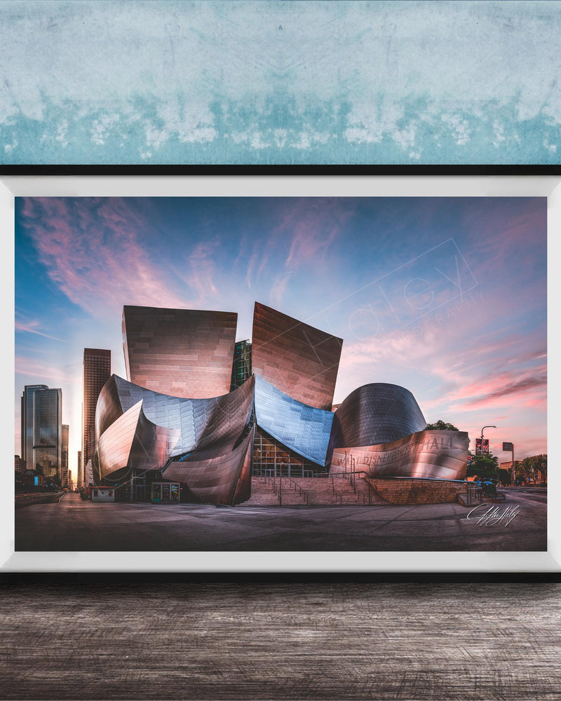 A framed photograph of the Guggenheim Museum in Bilbao, Spain, with its distinctive curved and metallic architecture against a colorful sunset sky.