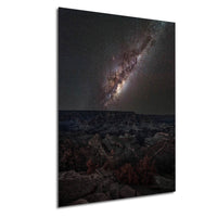 a breathtaking view of the night sky, showcasing a stunning galaxy with vibrant colors and intricate patterns. The galaxy is set against a dark, rocky landscape, creating a striking contrast between the celestial spectacle and the rugged terrain below. The image captures the beauty and vastness of the universe, inviting the viewer to marvel at the wonders of space.
