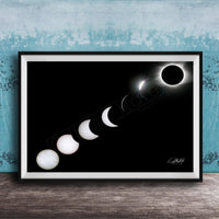A framed image depicting the solar eclipse, showing the moon transitioning from a crescent to a full moon, with the sun partially obscured by the moon.