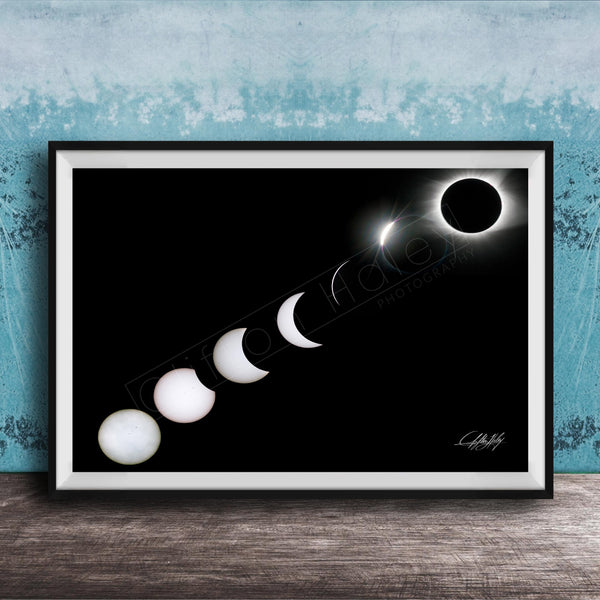 A framed image depicting the solar eclipse, showing the moon transitioning from a crescent to a full moon, with the sun partially obscured by the moon.