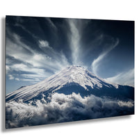 A majestic snow-capped mountain peak rises above a dramatic sky filled with clouds, creating a breathtaking natural landscape.