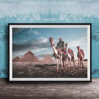 A framed photograph depicting a camel caravan in front of the iconic pyramids of Giza in Egypt.