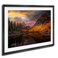 a serene mountain landscape with a lake reflecting the vibrant colors of the sky and surrounding trees.