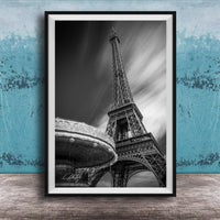 A black and white photograph of the Eiffel Tower in Paris, France, with a blurred background.