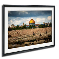 the Dome of the Rock, a significant landmark in Jerusalem, Israel. The golden dome of the mosque stands out against the cloudy sky, surrounded by lush greenery and a stone wall.