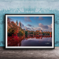 A framed photograph of the New York City skyline, with the city's iconic landmarks and trees reflected in the water below.