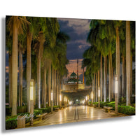 A serene night scene of a palm-lined pathway leading to a mosque, with the mosque's dome and minaret visible in the distance.