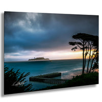 a serene coastal scene with a pier extending into the ocean, a small island in the distance, and a dramatic sky with clouds and a colorful sunset.