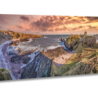 a stunning coastal landscape with rugged cliffs, a rocky shoreline, and a dramatic sky at sunset.