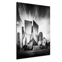 A striking black and white photograph of a modern, angular building with a unique architectural design, set against a cloudy sky.