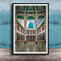 a grand, ornate building with a domed roof and arched windows, set against a blue wall.