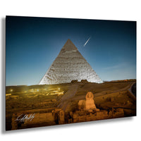 the Great Pyramid of Giza, a famous ancient Egyptian monument, illuminated at night against a starry sky.