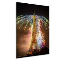 a tall tower with a large, colorful fireworks display lighting up the night sky behind it.