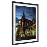 a historic building with a clock tower, illuminated at night against a dark sky.