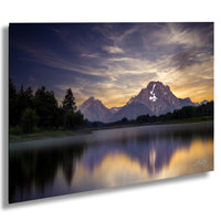 a serene landscape with a mountain range reflected in a calm lake, set against a dramatic sky with clouds.