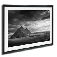 the iconic pyramids of Giza, Egypt, standing majestically against a dramatic cloudy sky.