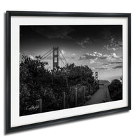 A black and white photograph of the Golden Gate Bridge in San Francisco, California, with a cloudy sky in the background.