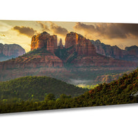 a breathtaking view of a mountainous landscape with towering red rock formations silhouetted against a dramatic sky at sunset.