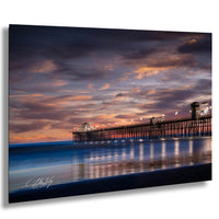 A serene coastal scene at sunset, with a long pier extending into the calm waters. The sky is filled with vibrant hues of orange and pink, creating a stunning backdrop for the pier. The image is a captivating blend of natural beauty and architectural structure, showcasing the harmonious coexistence of nature and human ingenuity.