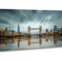 a cityscape with a large suspension bridge spanning a river, reflecting the city's skyline and the cloudy sky above.