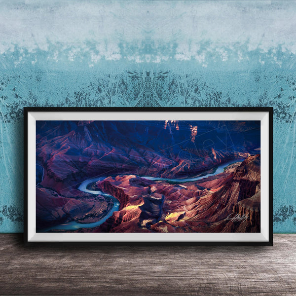 The image is a framed photograph of a breathtaking natural landscape, featuring a winding river surrounded by rugged mountains and valleys.