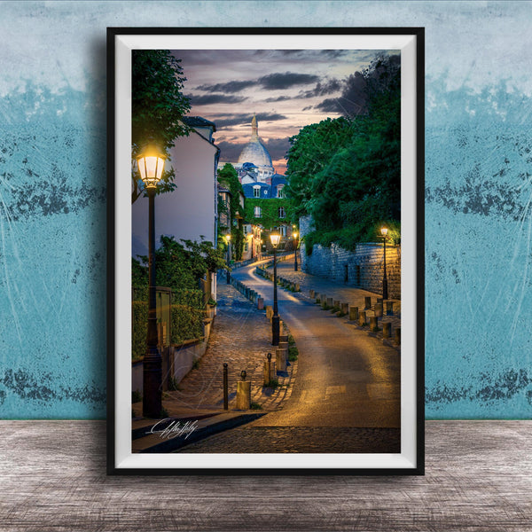 a picturesque street scene in Paris, France, with a cobblestone road lined with trees and lampposts, leading towards a large domed building at the end of the street.