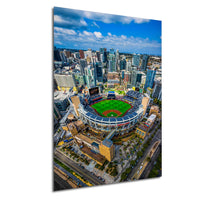 An aerial view of a baseball stadium surrounded by a cityscape of tall buildings.