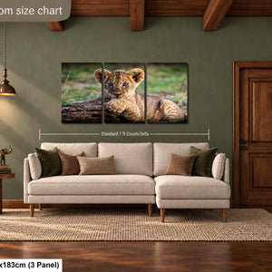 a living room with a large sofa, a wooden door, and a painting of a young lion cub on the wall.